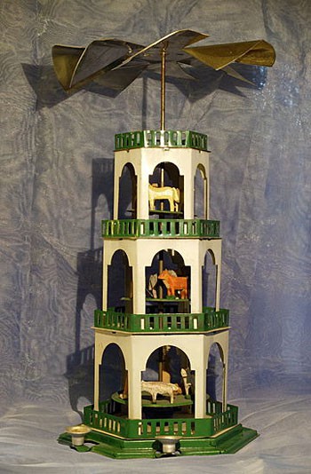 A German Christmas Candle Pyramid has a tower with 3 levels and a fan placed on top