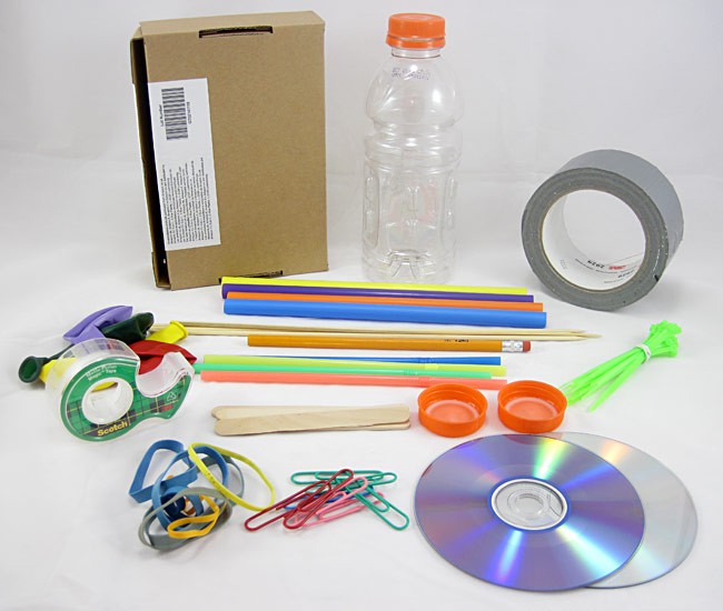 Cardboard, tape, a bottle, straws, balloons, zip ties, bottle caps, CD's, rubber bands, and paper clips