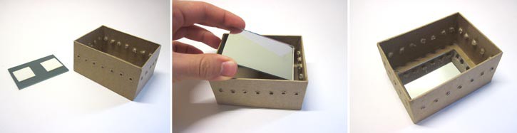 A mirror is placed at the bottom of a box and secured inside with double-sided tape