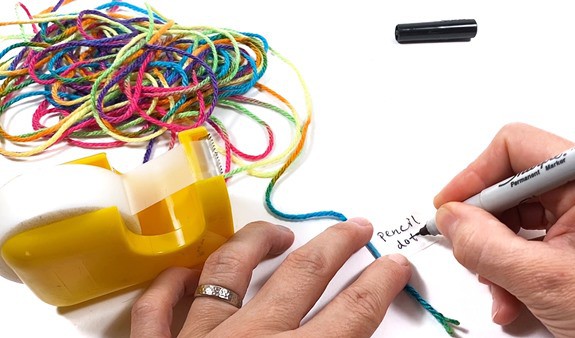 A 10-meter long piece of string with an attached label that says  'pencil dot'