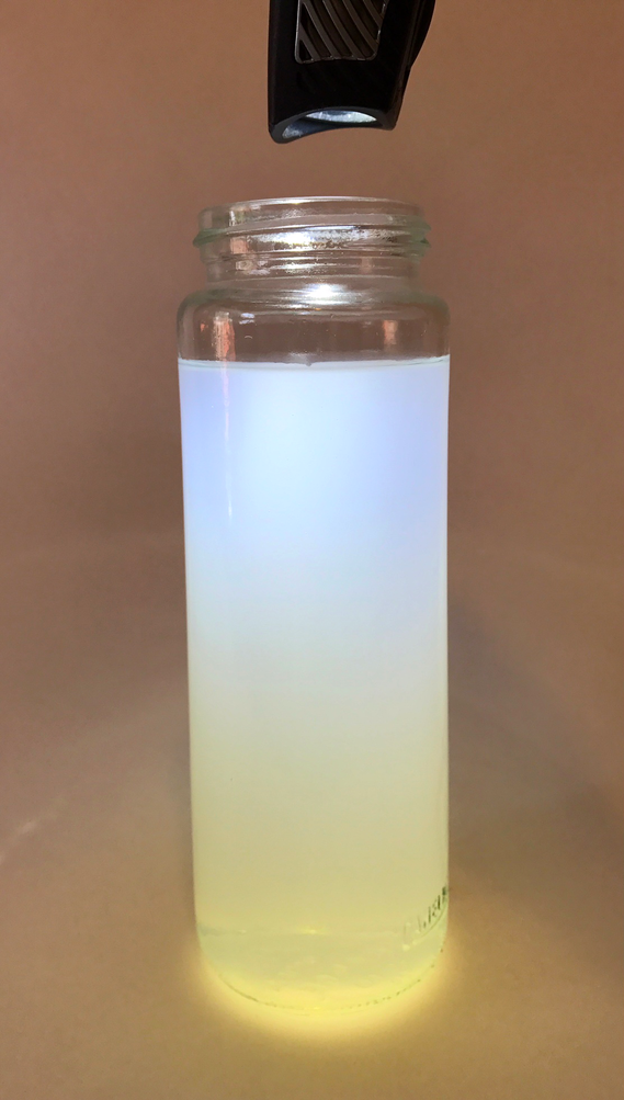 White light in a jar being used to show colors of sunset occur