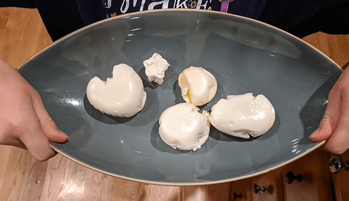 Student holding tray of hard-boiled eggs in different shapes like a star and a heart