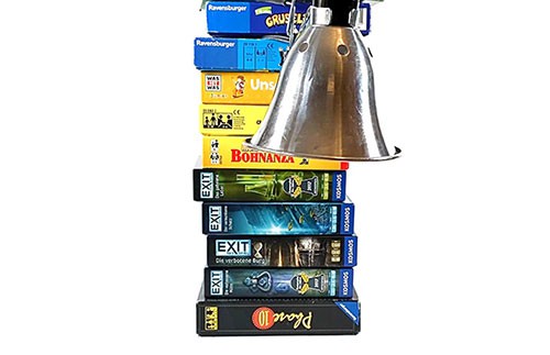 A lamp clamped to a stack of books.