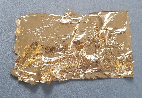 Using scrap metal leaf for next layer of gold leaf. 