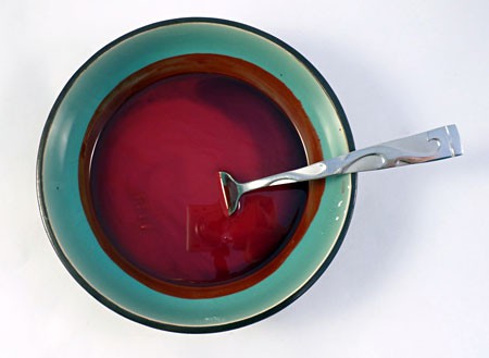 Cornstarch, water, corn syrup and red food coloring are mixed in a bowl with a fork