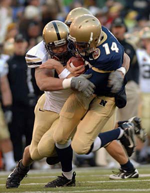 Photo of a football player being tackled on the field