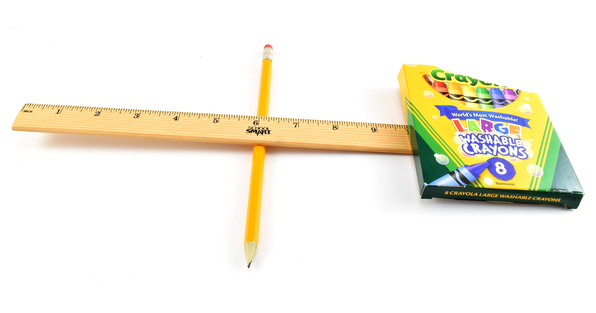 A lever made from a ruler and a pencil being used to lift a box of crayons