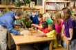 Students gathered around a table in front of a teacher