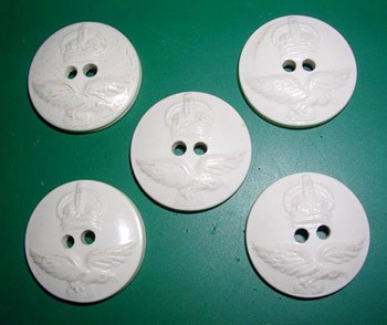 Five white buttons each have two holes punched through the center
