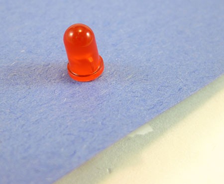 An LED bulb sits flush against a sheet of paper