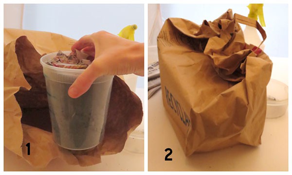A plastic pot filled with soil is placed inside of a paper bag