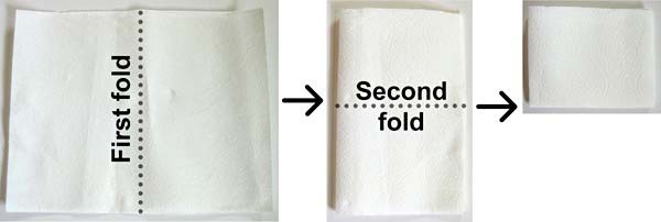 A sheet of paper towel is folded once width-wise and then again length-wise