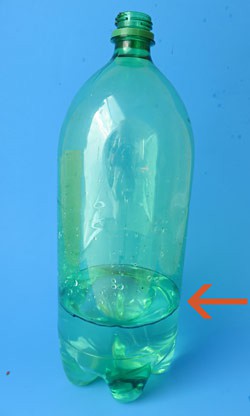 Water fills one third of a plastic bottle and a waterline is marked