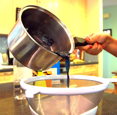 Boiled cabbage solution being poured over a strainer