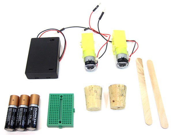 A battery pack, 3 double A batteries, mini breadboard, two DC motors, two corks and two popsicle sticks
