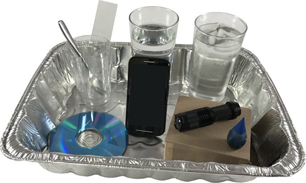 Three cups, a spoon, strips of plastic, a flashlight, blue food dye, a CD, a smartphone, a thermometer and an aluminum tray