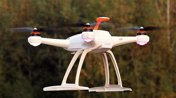 A small drone with 4 rotors hovering in the air.