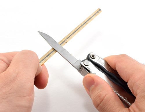 A wooden pencil is cut in half length wise with a knife