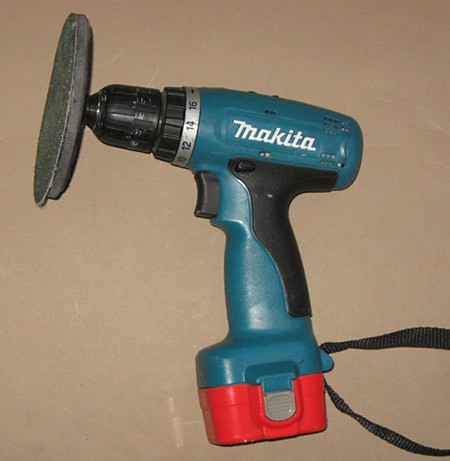 Photo of a cordless drill with a sanding disk attached