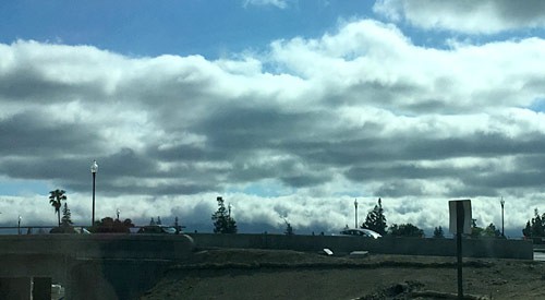 A low layer of gray clouds above a town