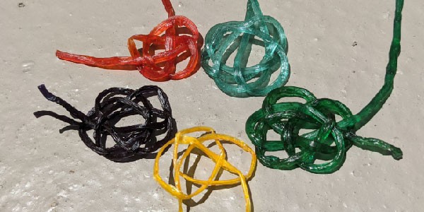 Knots tied from algae string in various colors arranged in a circle 