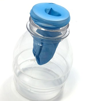 Cut bottle placed on the wide opening with a balloon hanging from the neck of the bottle.