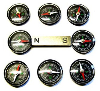 Eight compasses arranged in a square around a bar magnet with the north pole pointing left and south pole pointing right