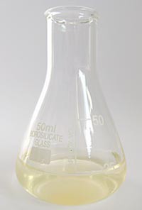 An erlenmeyer flask is filled with a faintly orange solution