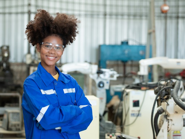 Female engineer working welding robotics arm