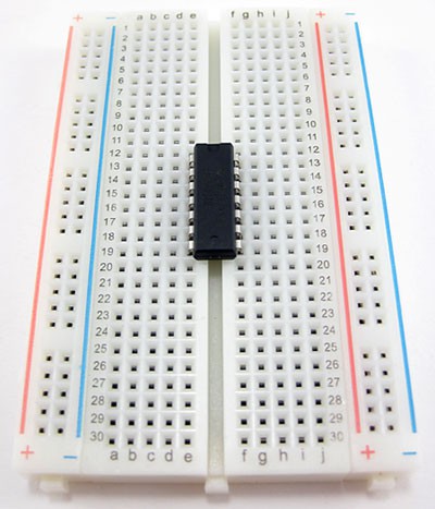 An integrated circuit bridges the gap in the center of a breadboard