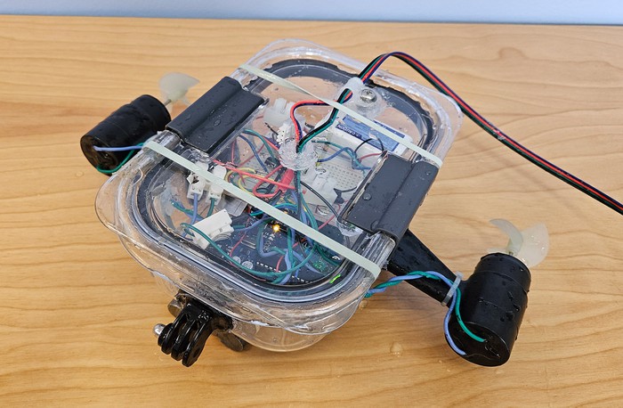 Assembled ROV with thrusters mounted on two sides and electronics inside the plastic container. 