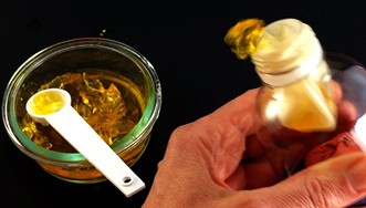 A  bowl of gelatin and lung model made from a bottle and a balloon from which gelatin is being pushed out.
