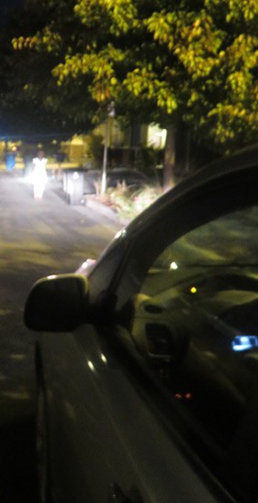 Photo of a cars headlights shining on a person at night