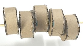 5 short cylinders threaded onto a skewer. Two cylinders seem centered on the skewer while the other three seem to stick out to the front, the top, or the bottom.   