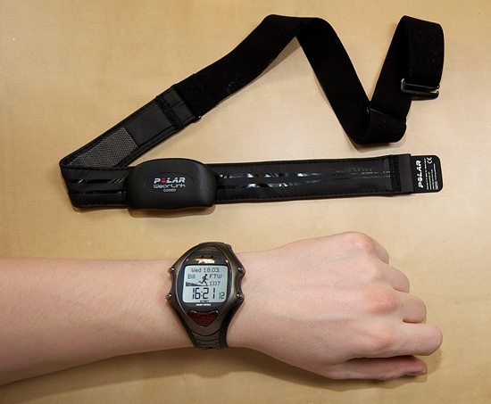 A heart rate monitor with a chest strap next to a wristwatch