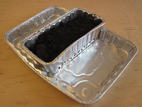 Aluminum bread pan filled with soil placed on an aluminum baking tray