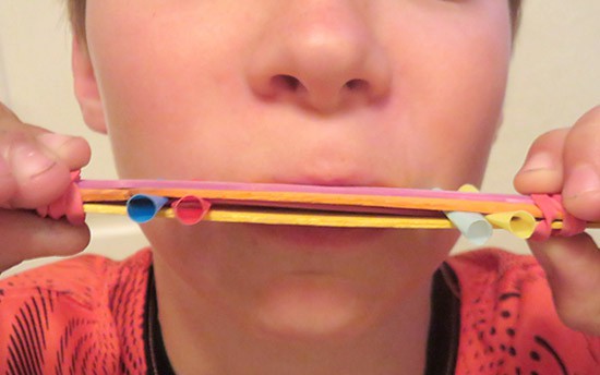 Homemade harmonica made from popsicle sticks, straws and rubber bands