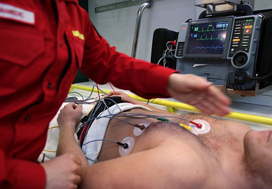 Circular electrode pads are attached to a man's chest