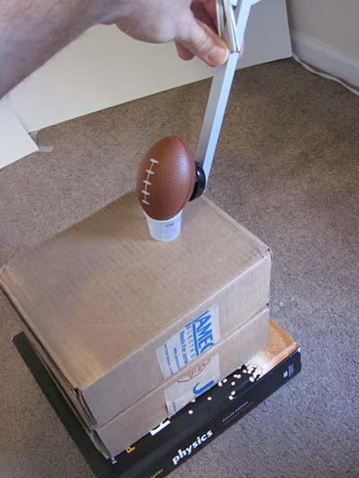 A small football rests on various textbooks and a cardboard box