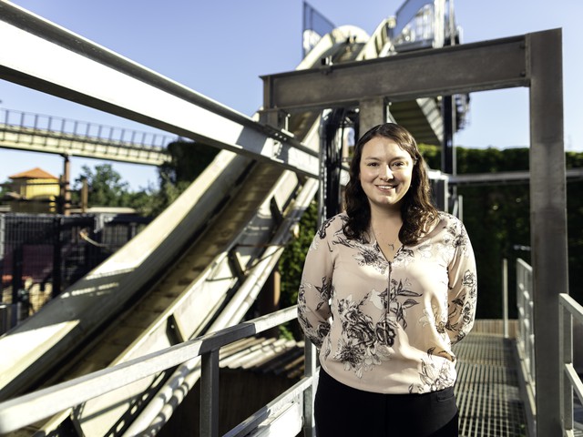 woman engineer with rollercoaster behind her