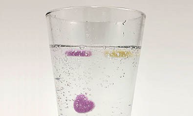 Candy hearts floating in a glass of soda 