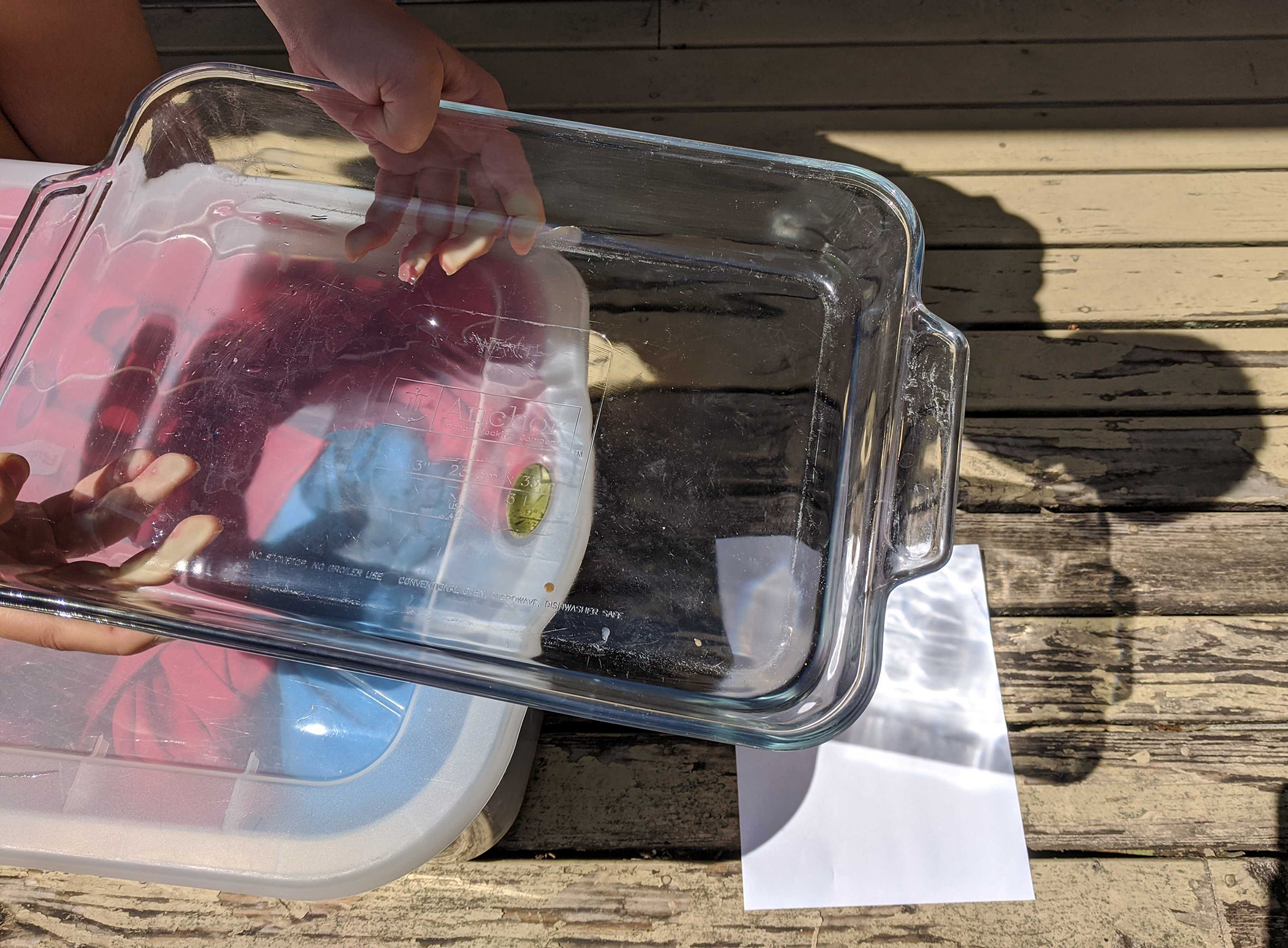 Setup with container of water and paper underneath to cast a rainbow