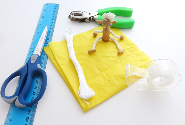 A ruler, scissors, string, tape, a hole punch and a small figurine
