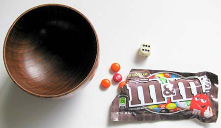 An open bag of M&M candies next to a bowl