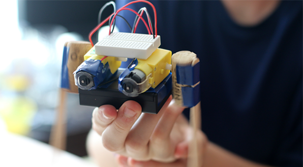 Student holding Flippy the dancing robot