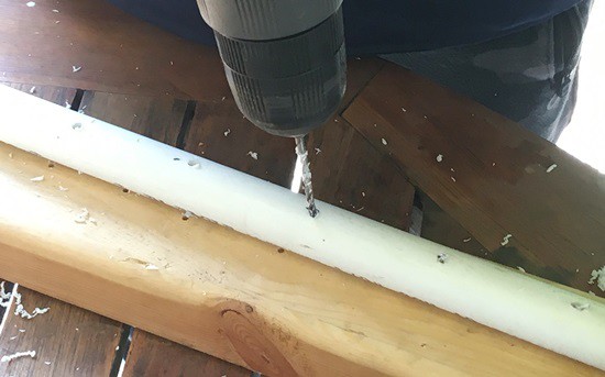 Person drilling about 1mm diameter holes into a PVC pipe. The holes are evenly spread out along one side of the pipe, with about 3 inches between holes. 
