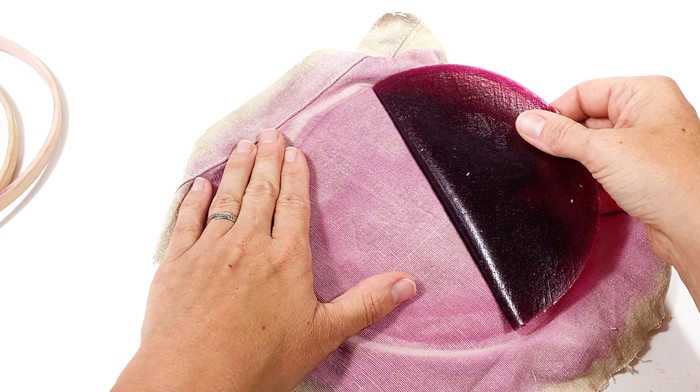 A hand peels the dried alginate mixture from the canvas. 