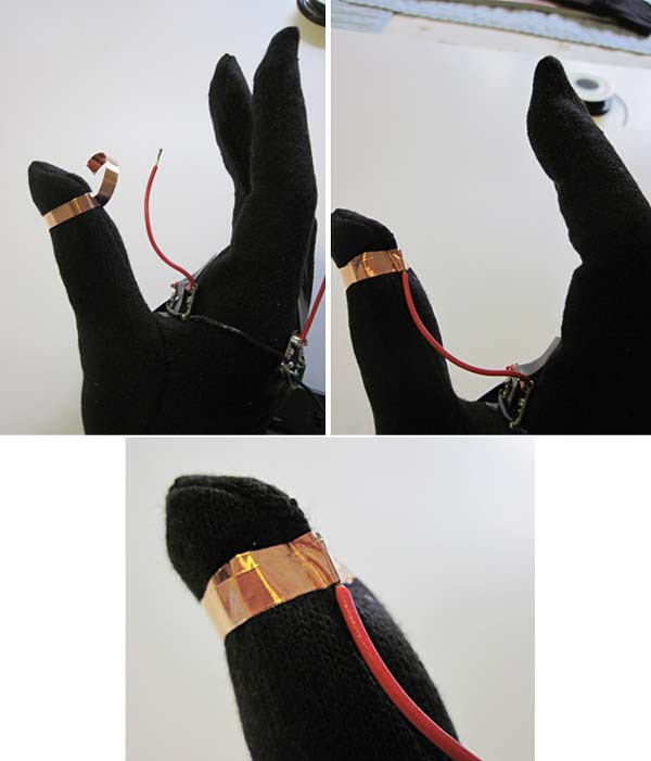 Copper tape secures a red wire to the thumb on a glove
