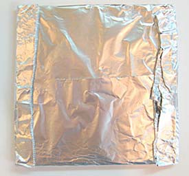 A cardboard square is wrapped in a layer of aluminum foil