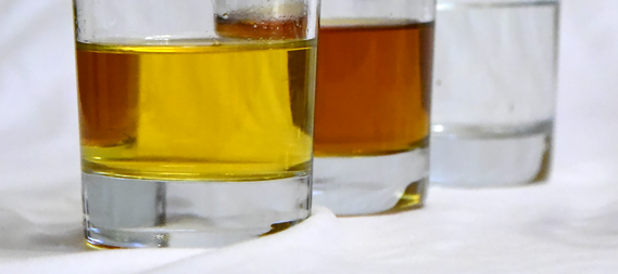 Three glasses with liquids after the distillation of apple juice